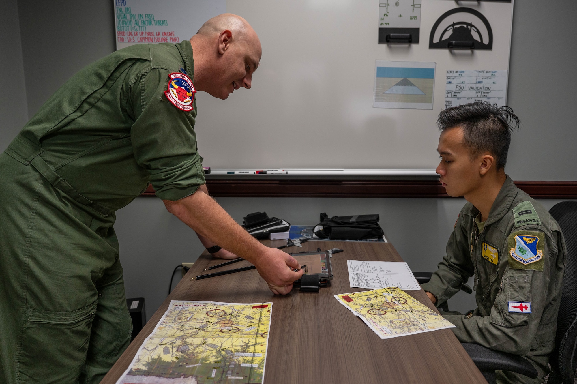 Commander briefs student pilot on upcoming flight.