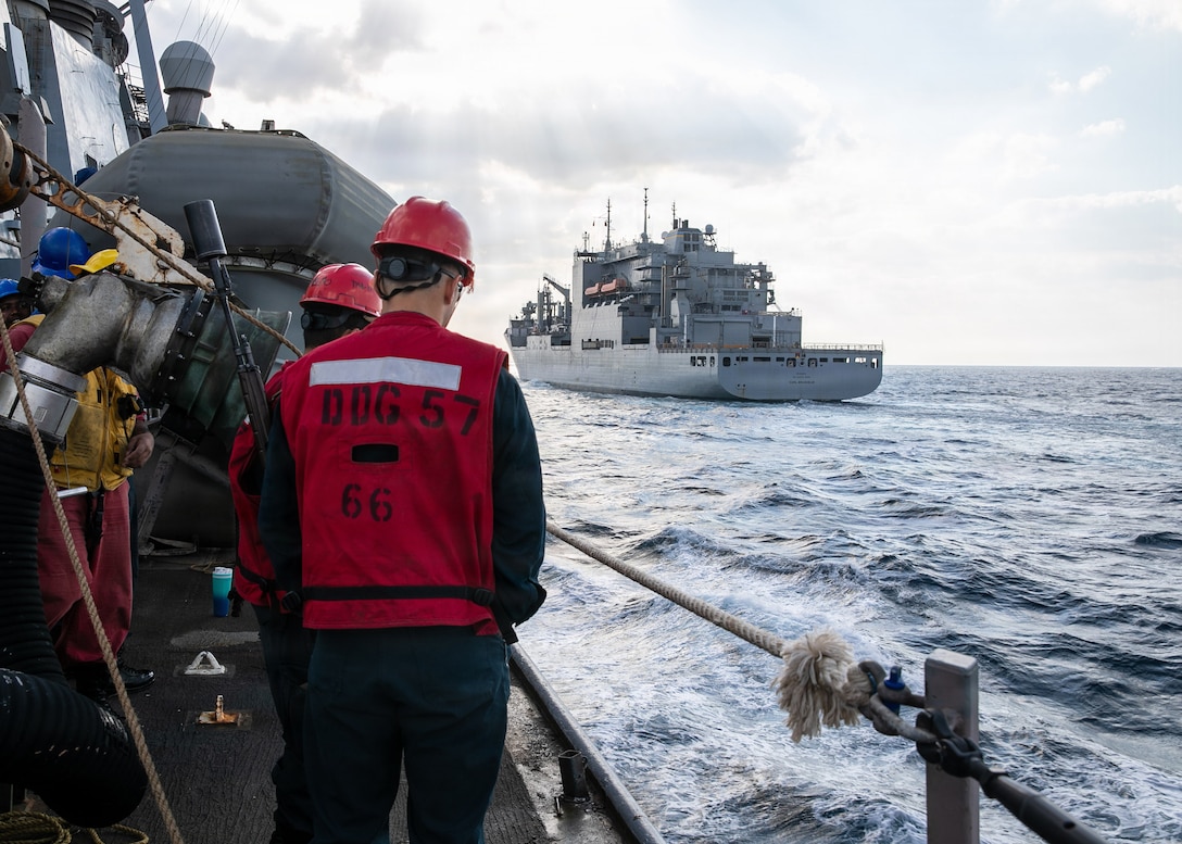 U.S. Sailors, assigned to the Arleigh Burke-class guided-missile destroyer USS Mitscher (DDG 57), prepare for a replenishment-at-sea as the ship approaches the Lewis and Clark-class dry cargo ship USNS Carl Brashear (T-AKE 7), Jan. 18, 2025. Mitscher is deployed to the U.S. 5th Fleet area of operations to support maritime security and stability in the U.S. Central Command area of responsibility.