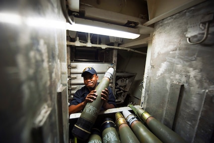 ATLANTIC OCEAN – U.S. Navy Gunner’'s Mate Seaman Desmond Summers removes a Mark 45 5-inch round from an ammunition bin aboard the guided missile destroyer USS Arleigh Burke (DDG 51) Feb. 26, 2014, in the Atlantic Ocean. Onboard today’s naval warships, some of the most critical weapons tasks still depend on human muscle. Automating projectile handling could make the task safer and more efficient. (U.S. Navy photo by Mass Communication Specialist 2nd Class Carlos M. Vazquez II/Released)
