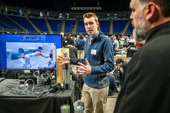 Keller Mardis, a senior electrical engineering student at Penn State, explains how the end-of-arm tool works when attached to a robotic arm. Mardis, along with four other students, developed the prototype as part of a Naval Surface Warfare Center Dahlgren Division-sponsored capstone project.
