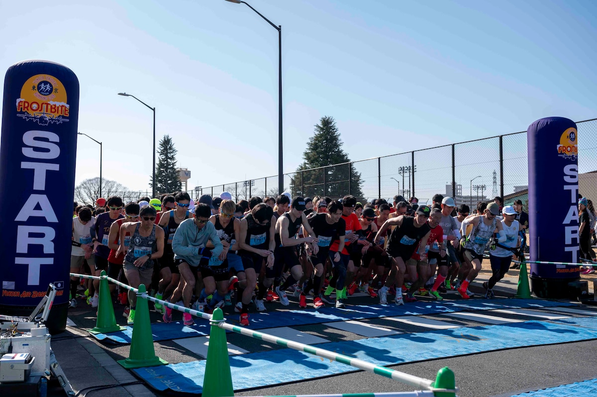 A large group of runners prepare to run across the starting line.