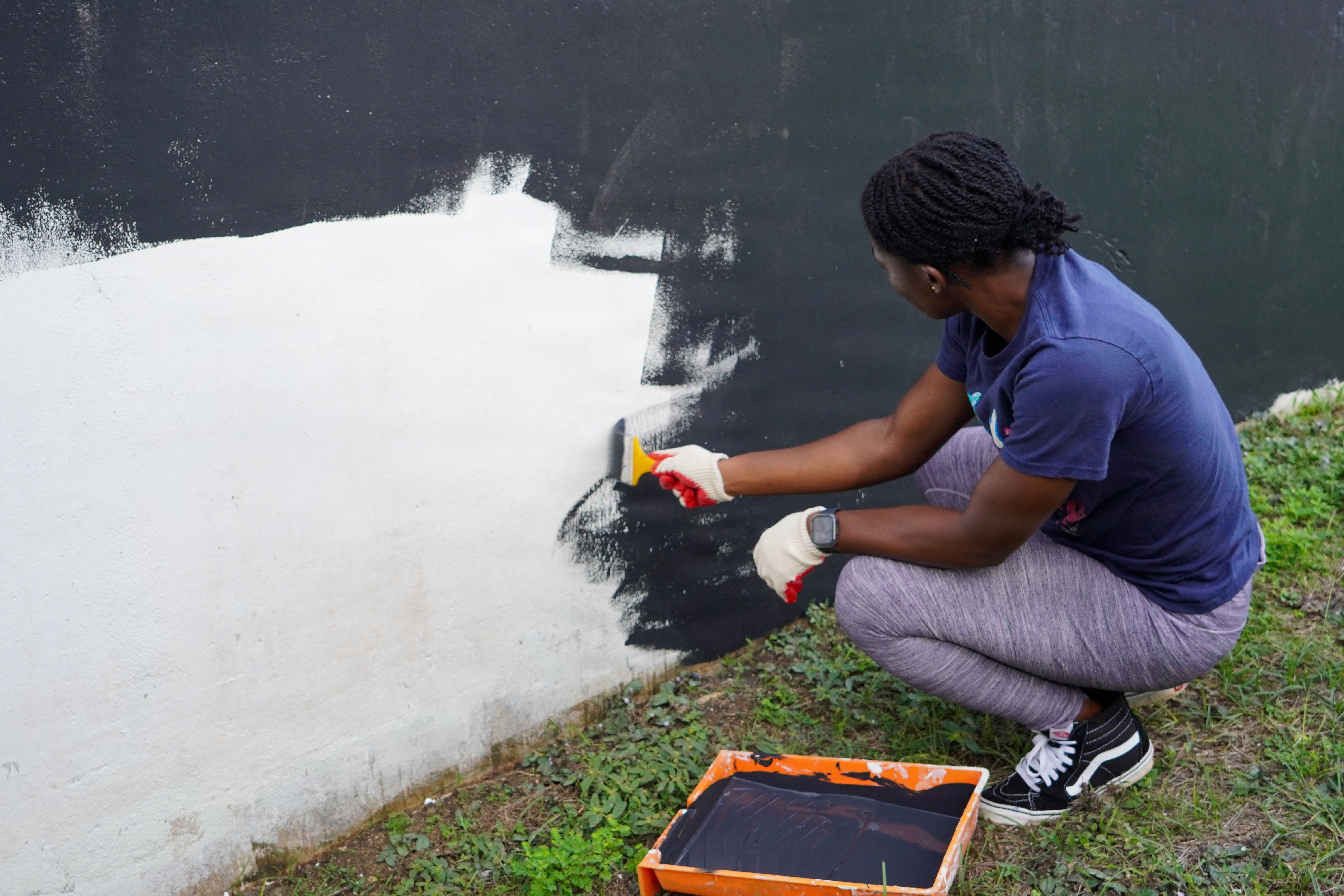U.S. Marine Corps Sgt. Lawrencia Fosu, personnel clerk, Headquarters Company, Marine Corps Base Camp Blaz, paints the back wall of a crypt during a revitalization project at Veterans Cemetery, Piti, Guam, Jan. 10, 2026. Service members partnered with The American Red Cross and Guam Veterans Affairs to help revitalize the cemetery grounds and honor the veterans and their families that were laid to rest there. (U.S. Marine Corps photo by Lance Cpl. Afton Smiley)
