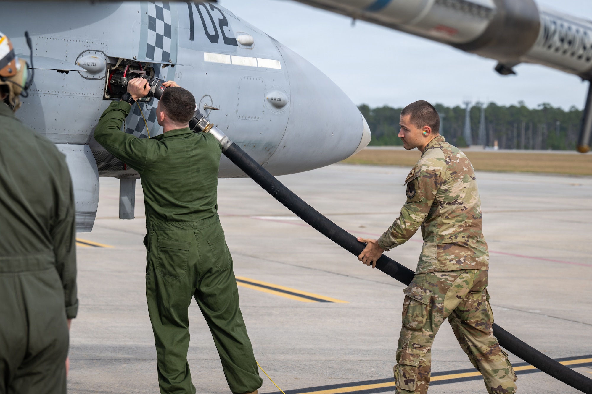 A U.S. Air Force Airmen assigned to the 23d Logistic Readiness Squadron and a U.S. Marine Corps airframes mechanic assigned to Marine Fighter Attack Squadron 312 fuel an F/A-18C Hornet during Combat Search and Rescue Training Exercise 26-1 at Moody Air Force Base, Georgia Jan. 12, 2026. Marine and Air Force aircrews trained together to integrate strike and rescue capabilities in joint recovery scenarios. (U.S. Air Force photo by Senior Airman Iain Stanley)