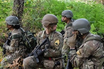 U.S. Army officer candidates listen on the radio for word from the platoon sergeant to advance their position while taking part in a platoon situational training exercise during Officer Candidate School, or OCS, Phase III at Joint Base Lewis-McChord, Wash., Aug. 5, 2025.