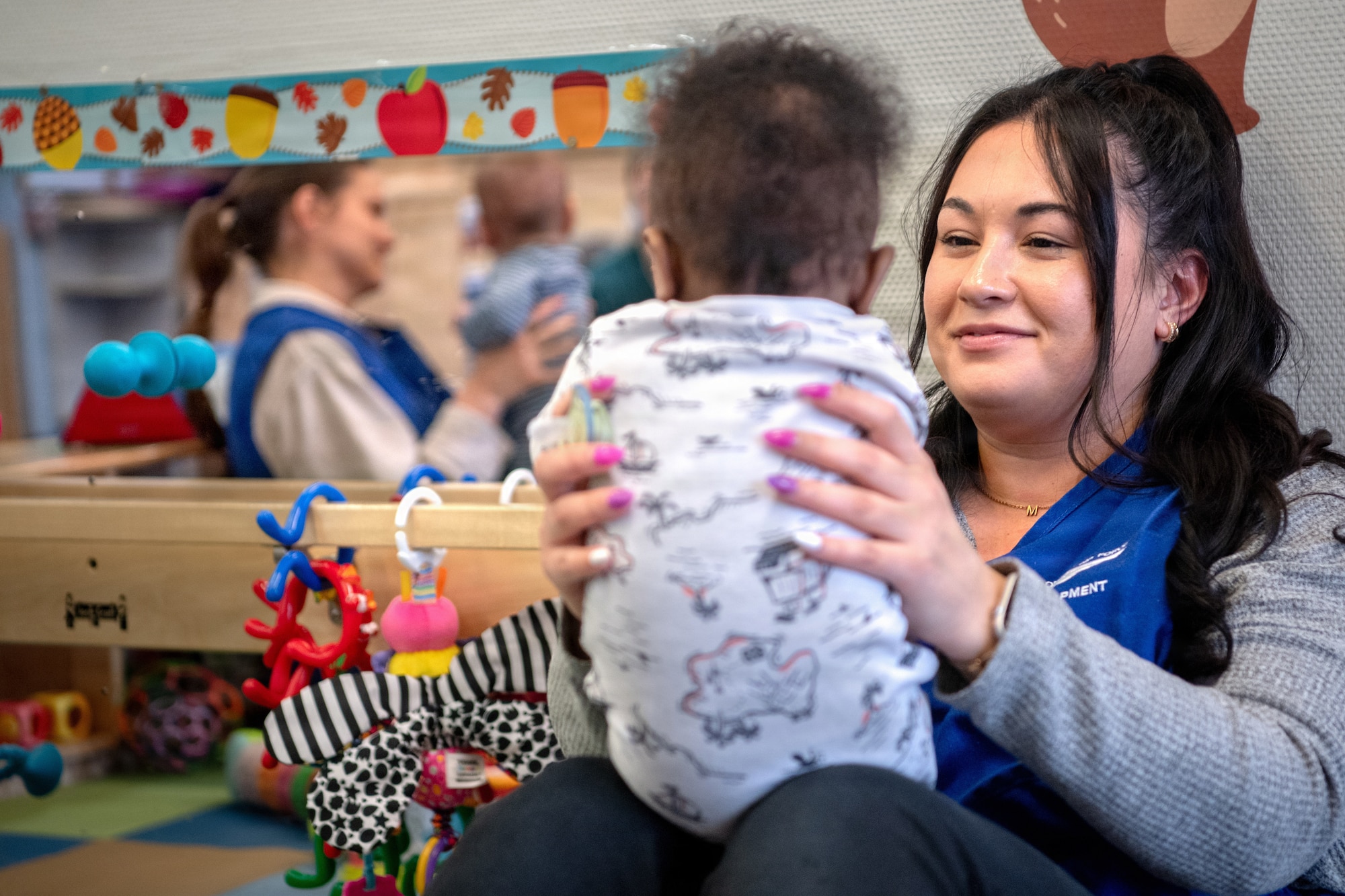 Courtney Jadvani, 86th Child Development Center education technician, embraces a child of a service member at Ramstein Air Base, Germany, Jan 14. 2026.