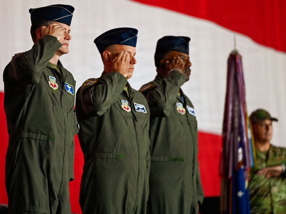 Three commander salute from onstage during a change of command.