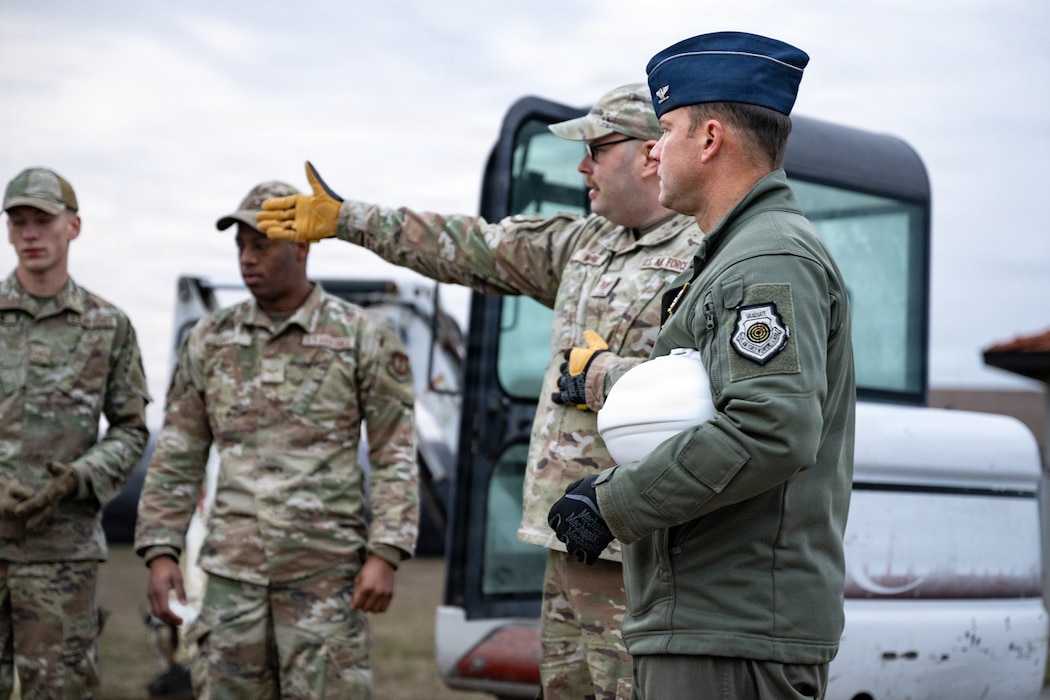 Airman points to a site with a colonel looking in the same direction.