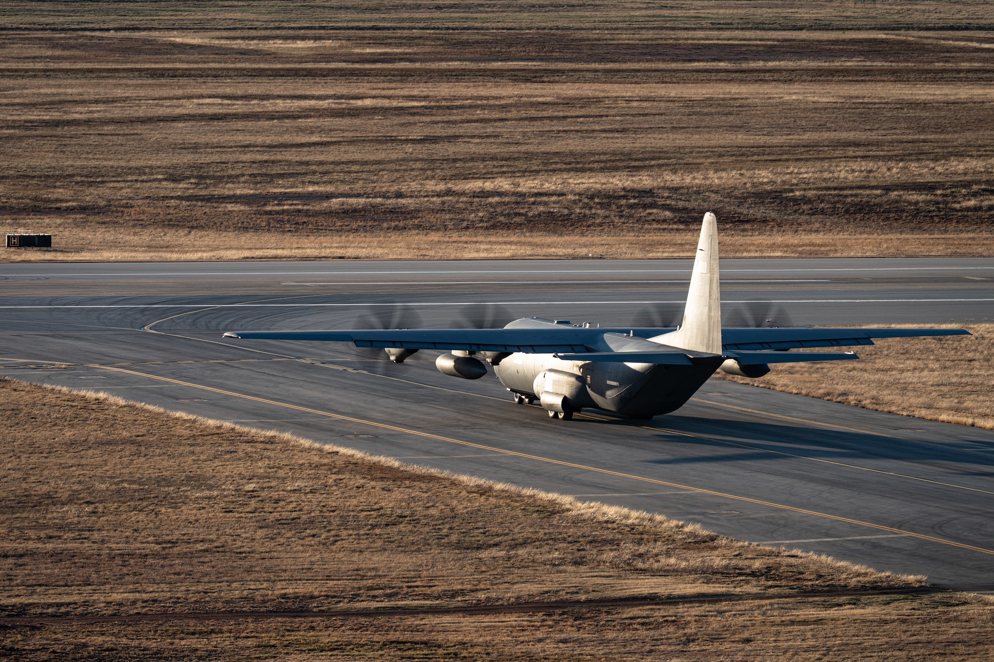 A U.S. Air Force C-130J Super Hercules equipped with external fuel tanks  assigned to the 317th Airlift Wing taxis to the runway prior to a Maximum Endurance Operation at Dyess Air Force Base, Texas, Jan. 12, 2026. The mission represented the 317th AW’s 10th MEO into the Indo-Pacific region, demonstrating the wing’s ability to project tactical airlift with minimal ground time during refueling stops. (U.S. Air Force photo by Senior Airman Jade M. Caldwell)
