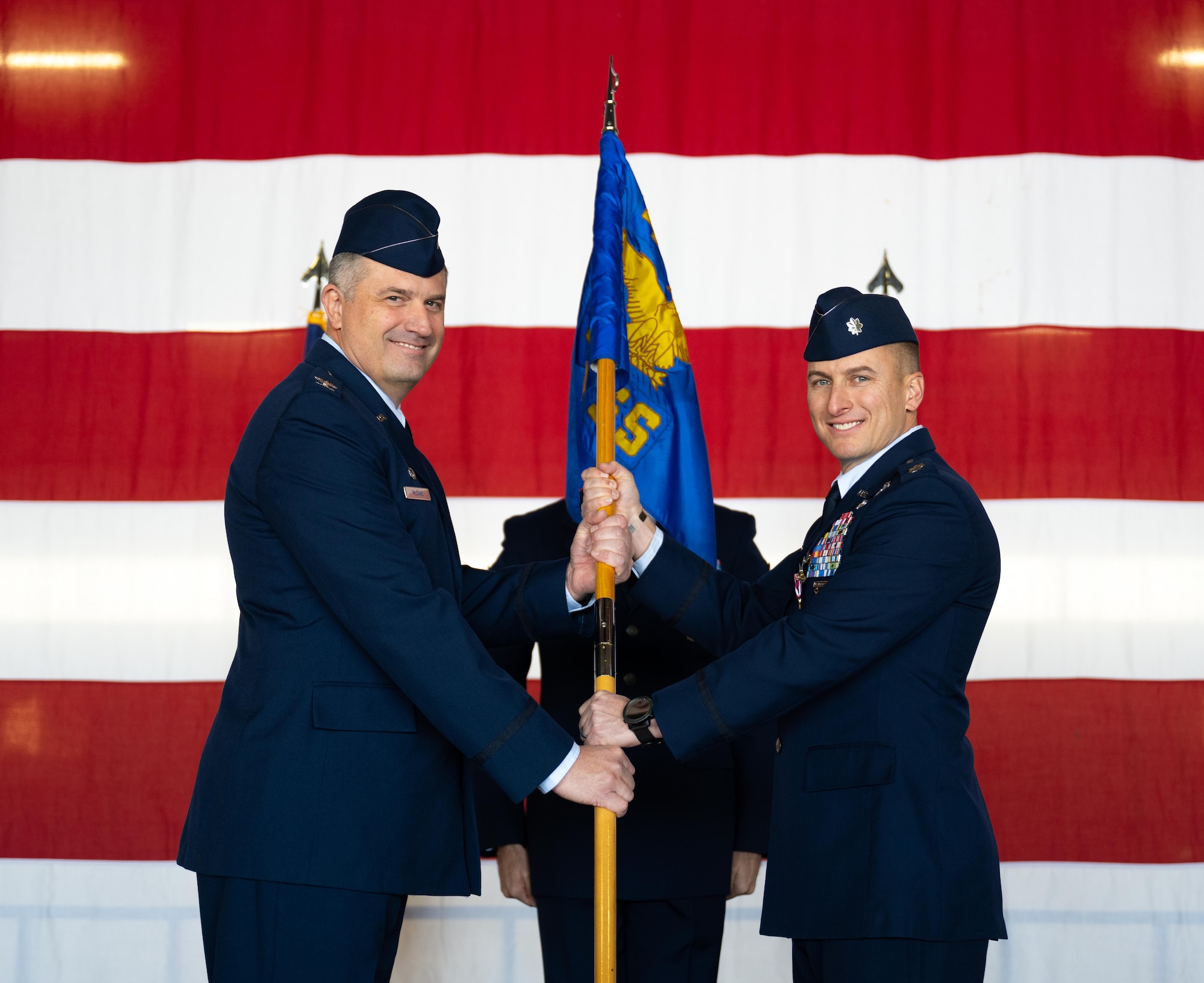 U.S. Air Force Col. Joseph McCane, 47th Operations Group commander, left, receives the squadron guidon from Lt. Col. Daniel Garrison, 47th Operations Support Squadron (OSS) outgoing commander, right, during the 47th OSS change of command ceremony at Laughlin Air Force Base, Texas, Jan. 16, 2026. In a change of command ceremony, the guidon symbolizes the transfer of command, as well as the authority and responsibility associated with it. (U.S. Air Force photo by Airman 1st Class Harrison Sullivan)