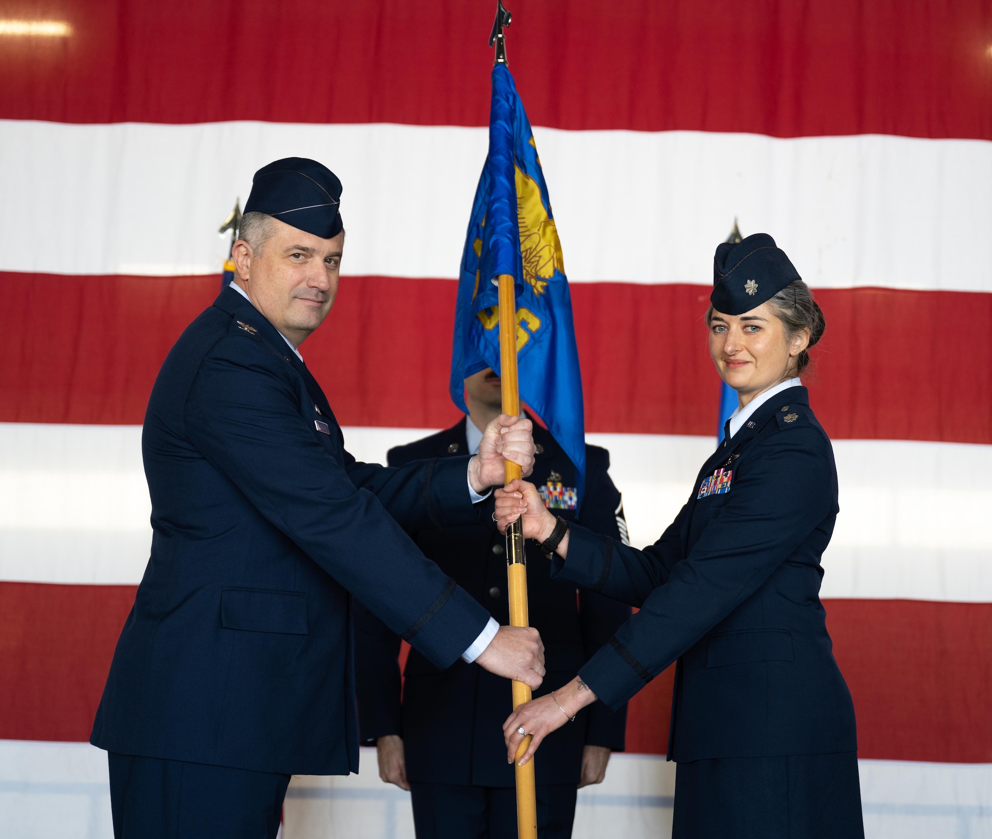 U.S. Air Force Col. Joseph McCane, 47th Operations Group commander, left, presents the squadron guidon from Lt. Col. Amanda Thorsen, 47th Operations Support Squadron (OSS) incoming commander, right, during the 47th OSS change of command ceremony at Laughlin Air Force Base, Texas, Jan. 16, 2026. In a change of command ceremony, the guidon symbolizes the transfer of command, as well as the authority and responsibility associated with it. (U.S. Air Force photo by Airman 1st Class Harrison Sullivan)