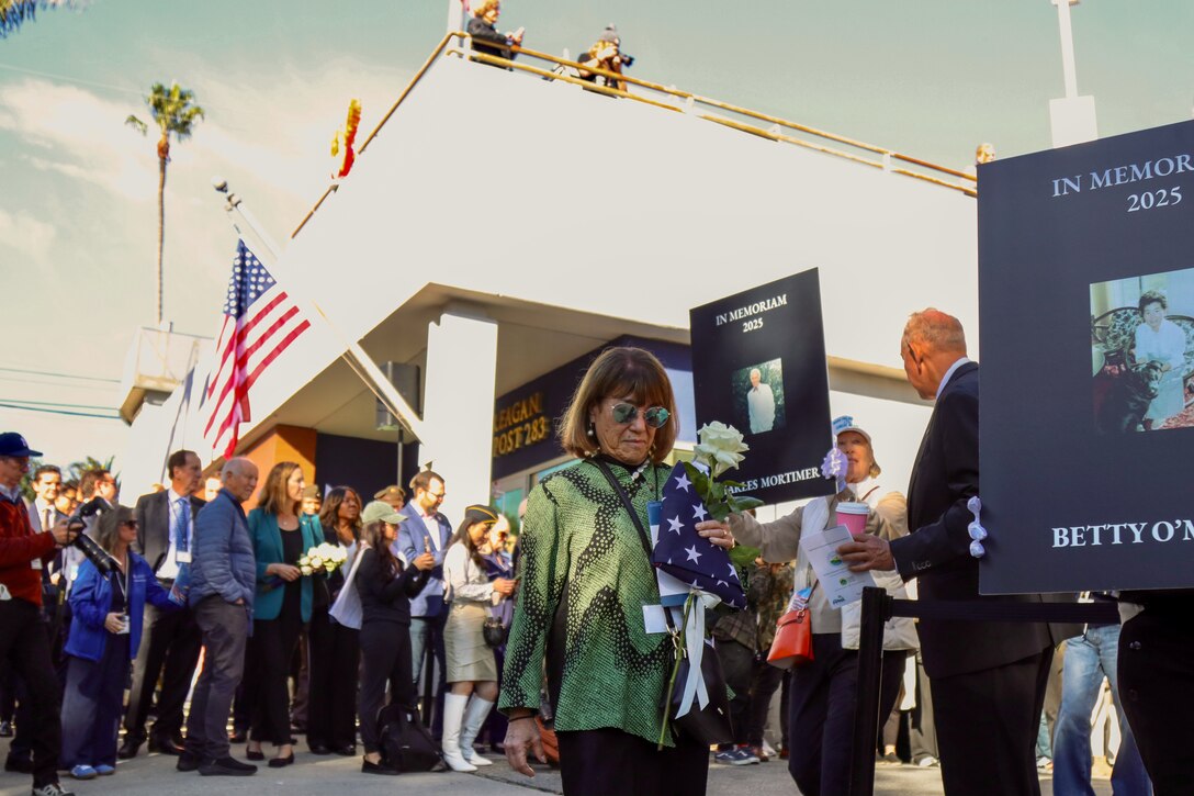 Families who lost loved ones in the deadly Palisades Wildfires gather Jan.7, while holding tribute placards, flags and flowers, as part of a community-wide remembrance event in front of the American Legion Post 283 in Pacific Palisades, California. (Photo by Shawn Davis, USACE LA District Public Affairs)