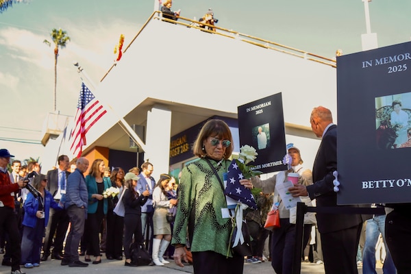 Families who lost loved ones in the deadly Palisades Wildfires gather Jan.7, while holding tribute placards, flags and flowers, as part of a community-wide remembrance event in front of the American Legion Post 283 in Pacific Palisades, California. (Photo by Shawn Davis, USACE LA District Public Affairs)