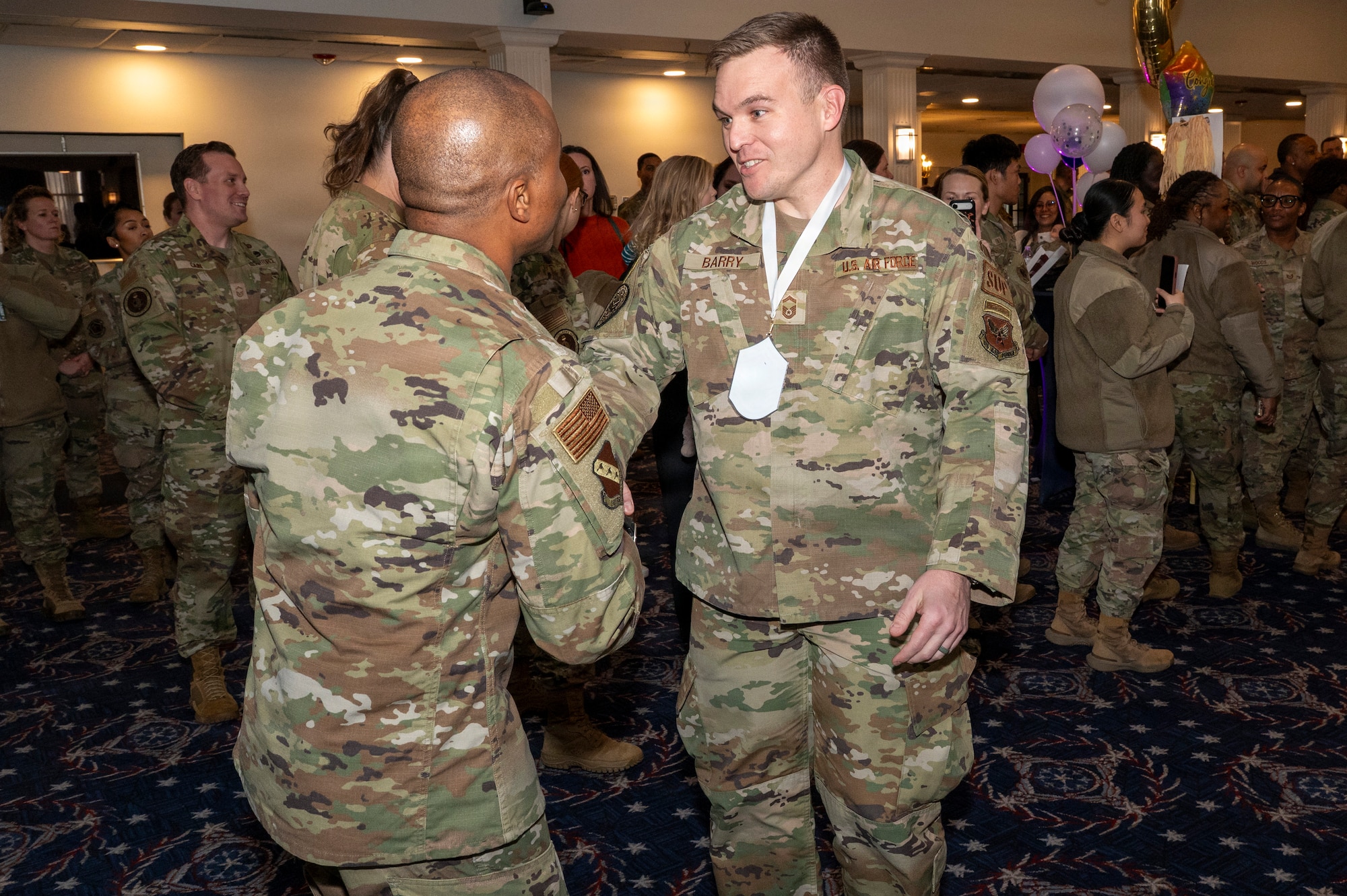 Senior Master Sgt. Philip Barry, Secretary of the Air Force Office of Special Trial Counsel, right, shakes hands with Chief Master Sgt. Anthony Thompson Jr., left, senior enlisted leader for Joint Base Anacostia-Bolling and the 11th Wing, command chief, during a chief master sergeant release party at JBAB, Washington, D.C., Jan. 15, 2026. Chief master sergeant, the highest enlisted rank, is held by just 1% of the Air Force's enlisted force. (U.S. Air Force photo by Hayden Hallman)