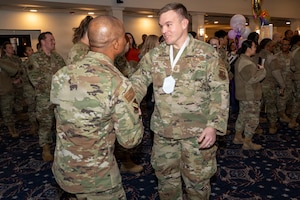 Senior Master Sgt. Philip Barry, Secretary of the Air Force Office of Special Trial Counsel, right, shakes hands with Chief Master Sgt. Anthony Thompson Jr., left, senior enlisted leader for Joint Base Anacostia-Bolling and the 11th Wing, command chief, during a chief master sergeant release party at JBAB, Washington, D.C., Jan. 15, 2026. Chief master sergeant, the highest enlisted rank, is held by just 1% of the Air Force's enlisted force. (U.S. Air Force photo by Hayden Hallman)