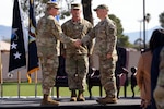 U.S. Air Force Lt. Gen. Evan L. Pettus, left, U.S. Southern Command acting commander shakes hands with Col. Brandon Alford, right, U.S. Space Forces Southern commander during an activation ceremony for U.S. Space Forces Southern at Davis-Monthan Air Force Base, Arizona, Jan. 21, 2026. SPACEFOR–SOUTH serves as the space component to U.S. Southern Command, responsible for integrating space power with joint, interagency and multinational partners to support regional security, deterrence and stability across Central America, South America and the Caribbean. (U.S. Air Force photo by Tech. Sgt. Rachel Maxwell)