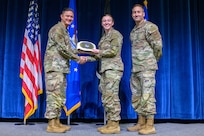 Three Servicemembers stand for an award presentation at Air Force Officer Training School