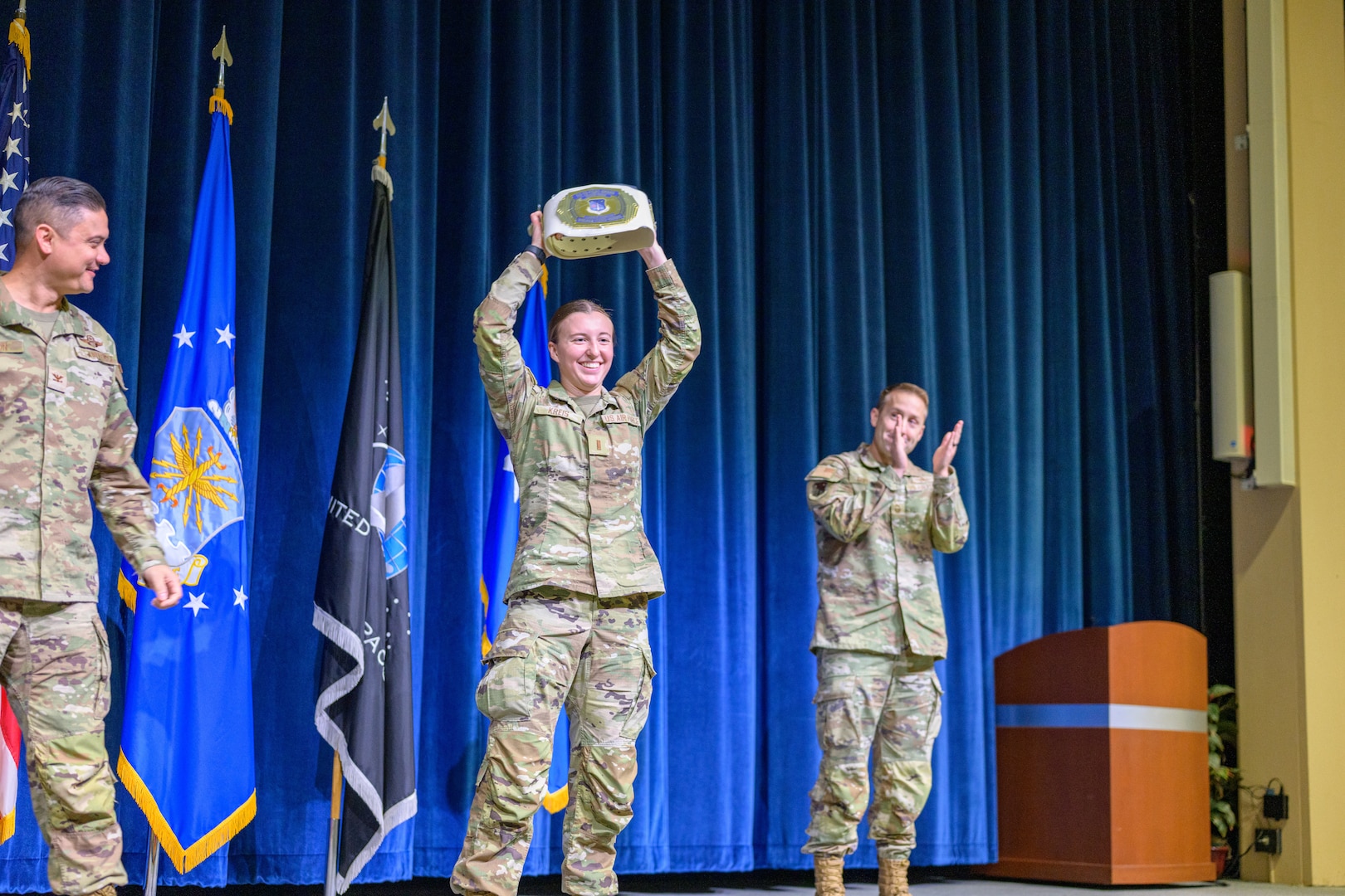 Three Servicemembers stand for an award presentation at Air Force Officer Training School