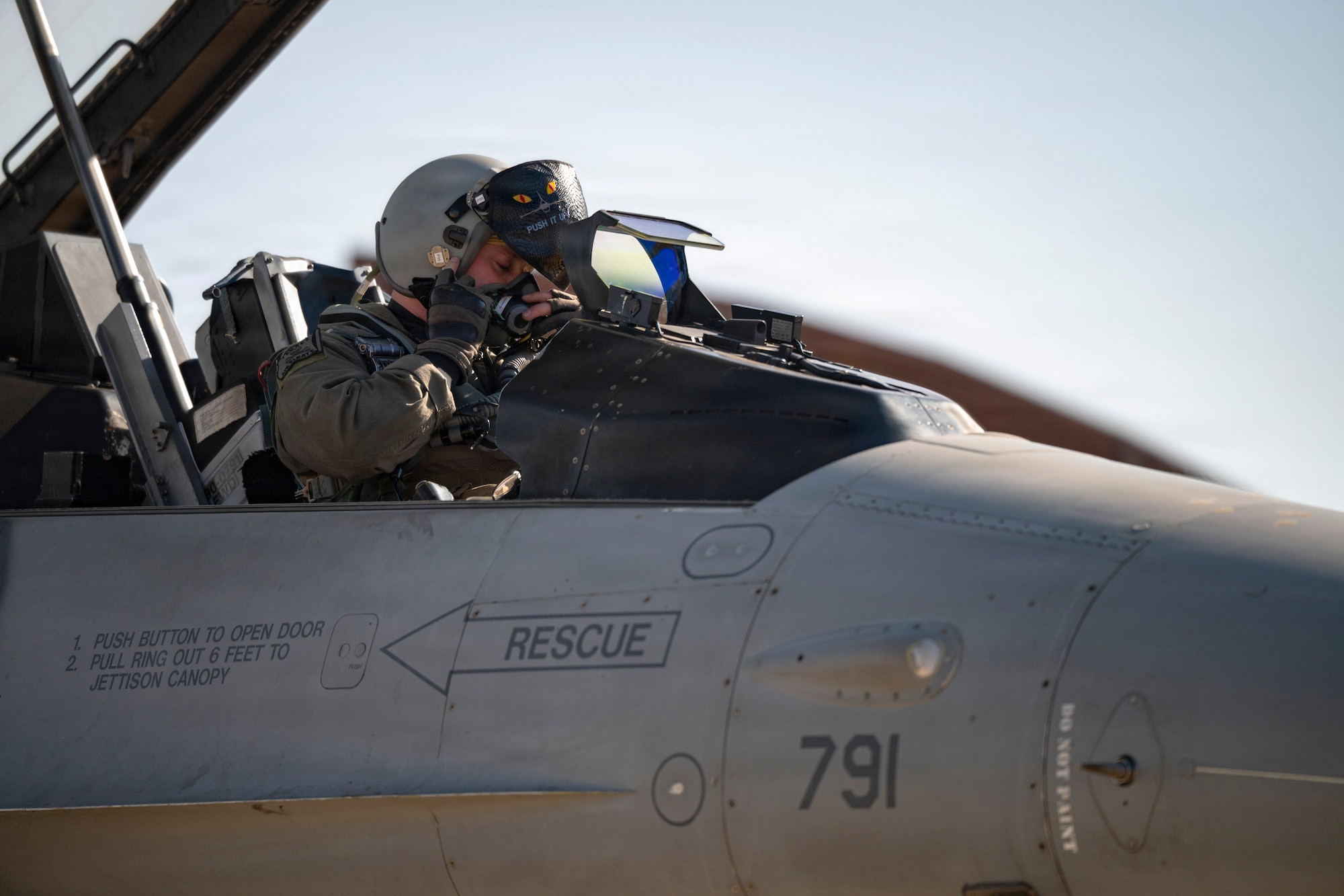 U.S. Air Force Capt. Griffin Line, 35th Fighter Squadron F-16 pilot, puts on his helmet and mask before a flight at Osan Air Base, Republic of Korea, Jan. 21, 2026.