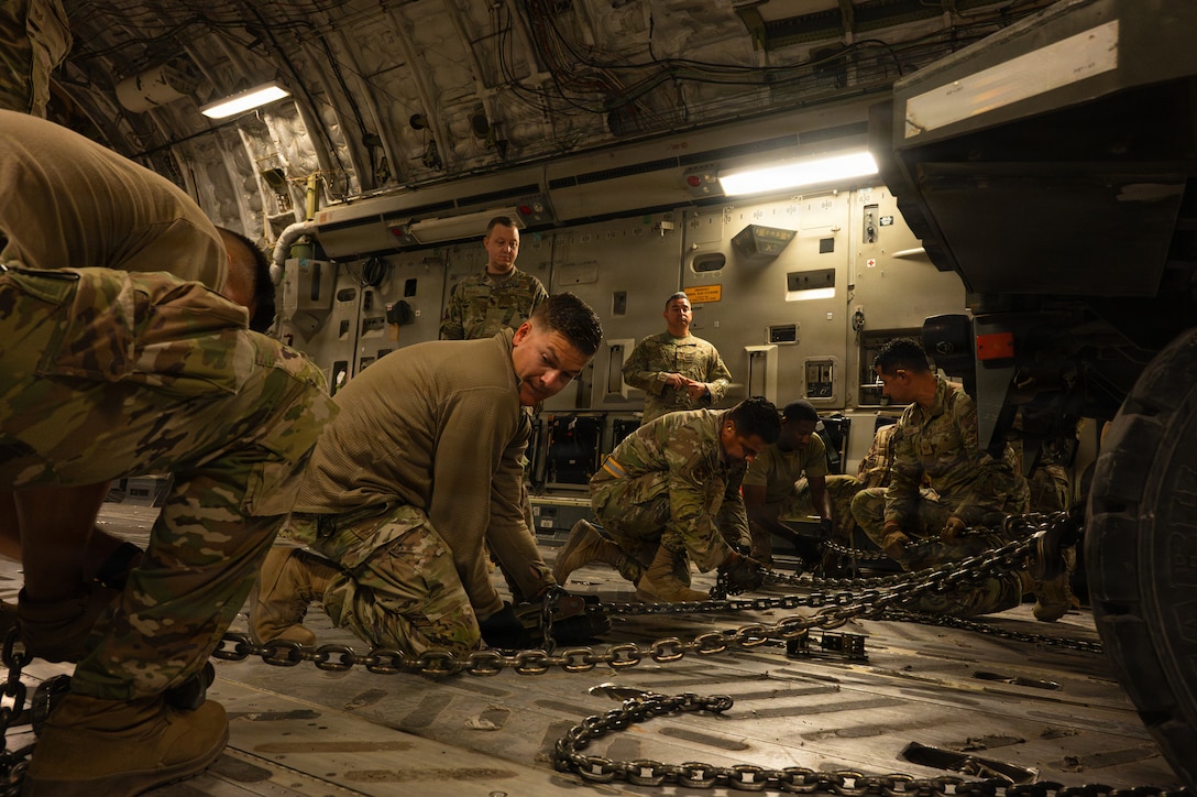 U.S. Airmen assigned to the 379th Expeditionary Aerial Port Squadron secure a K-loader for transport in a C-17 Globemaster III aircraft in support of a readiness exercise within the U.S. Central Command area of responsibility, Jan. 21, 2026. The exercise spanned across the CENTCOM AOR, elevating readiness with realistic scenarios that tested dispersed operations, rapid deployment of aircraft, and positive control over a large area. (U.S. Air Force photo by Senior Airman Joseph Garcia)