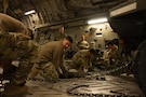 U.S. Airmen assigned to the 379th Expeditionary Aerial Port Squadron secure a K-loader for transport in a C-17 Globemaster III aircraft in support of a readiness exercise within the U.S. Central Command area of responsibility, Jan. 21, 2026. The exercise spanned across the CENTCOM AOR, elevating readiness with realistic scenarios that tested dispersed operations, rapid deployment of aircraft, and positive control over a large area. (U.S. Air Force photo by Senior Airman Joseph Garcia)