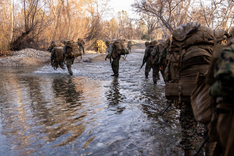 U.S. Marines cross through a river during a Cold Weather Field Exercise at Fort Hunter-Liggett, Calif. on Jan. 10th, 2026. The Marines are a part of Combat Logistics Battalion 23, 4th Marine Logistics Group. CLB-23 conducted a hike to transfer from one training area to another, designed to enhance and test readiness and lethality in the Marine Corps Reserve. (U.S Marine Corps photo by Sgt. Eduardo Delatorre)