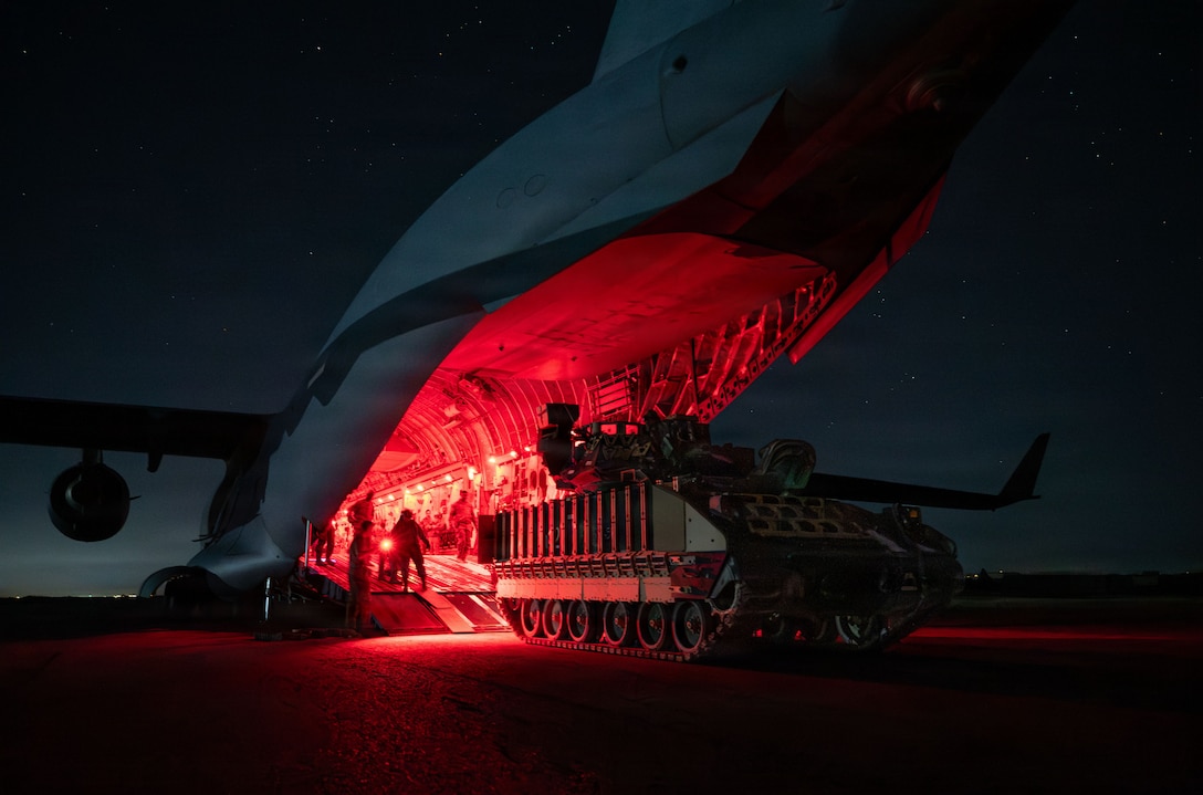 U.S. Airmen and Soldiers load a U.S. Army M2A3 Bradley tank onto a U.S. Air Force C-17 Globemaster III aircraft during an airbridge operation in the U.S. Central Command area of responsibility, Nov. 19, 2025. The 16th Expeditionary Airlift Squadron provided the aerial component of the airbridge operation for the U.S. Army’s 278th Armored Cavalry Regiment, 3rd Squadron, to transport the M2A3 Bradley and U.S. Soldiers. (U.S. Air Force photo by Tech. Sgt. Bailee A. Darbasie)