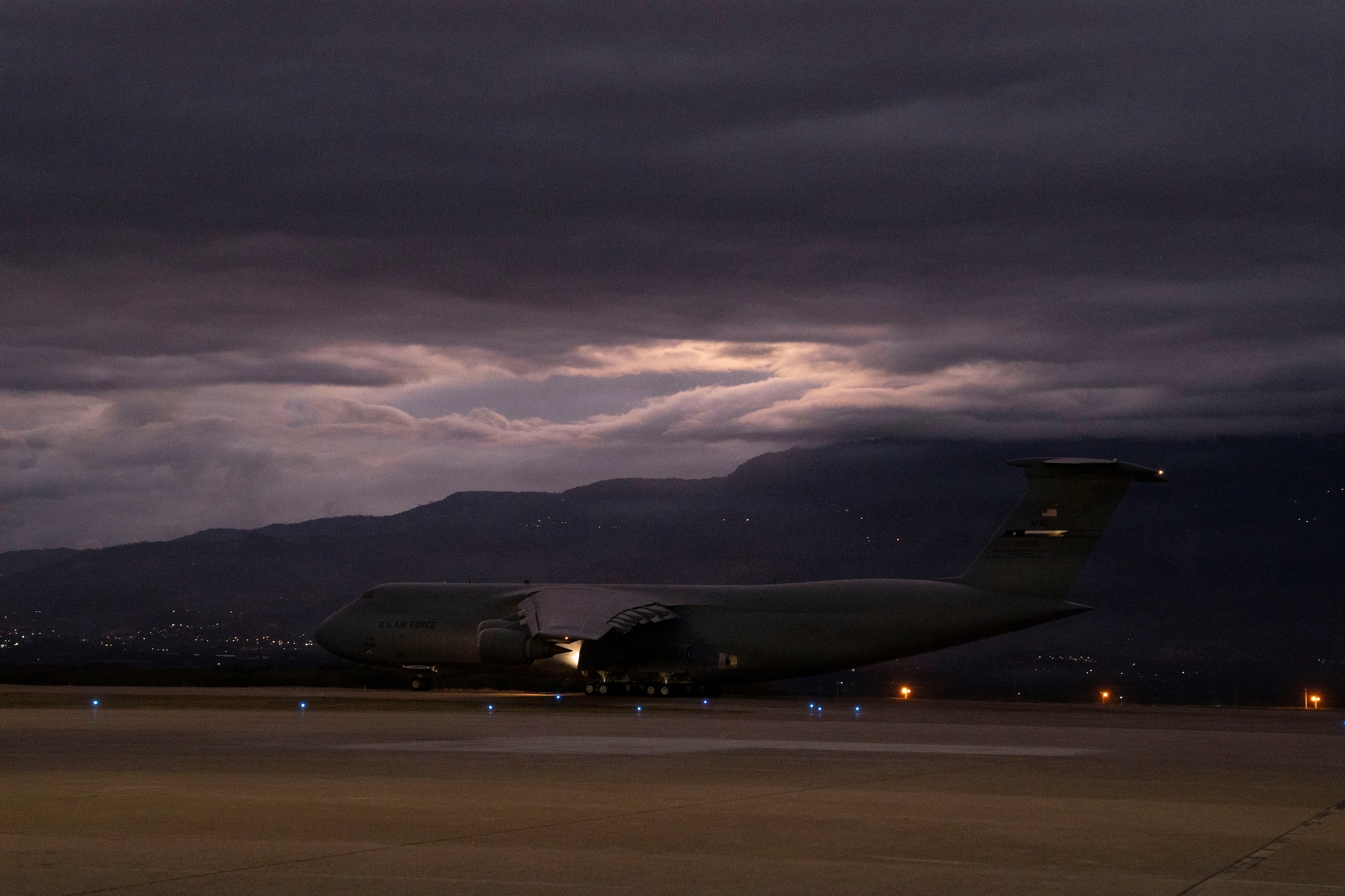 A military plane takes off from a runway.