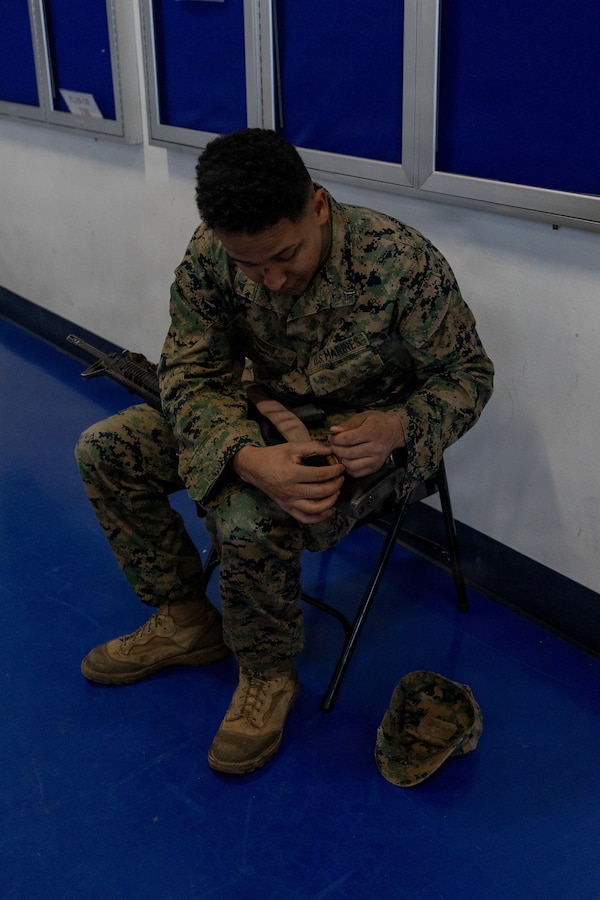 U.S. Marine Corps Lance Cpl. Samuel Bacchi, a motor vehicle operator, attaches a sling to his M16A4 rifle during preparation for a cold weather field exercise at Fort Hunter-Liggett, Calif., Jan. 9, 2026. Bacchi assigned to Combat Logistics Battalion 23, 4th Marine Logistics Group. Marines assigned to Combat Logistics Battalion 23, 4th Marine Logistics Group conducted an aerial insert with support from U.S. Army Bravo Company, 1st Battalion, 126th Aviation Regiment, from Stockton, Calif. during a platoon-level defense training by delivering Marines and crew-served weapons directly into the training ground. (U.S Marine Corps photo by Sgt. Eduardo Delatorre)