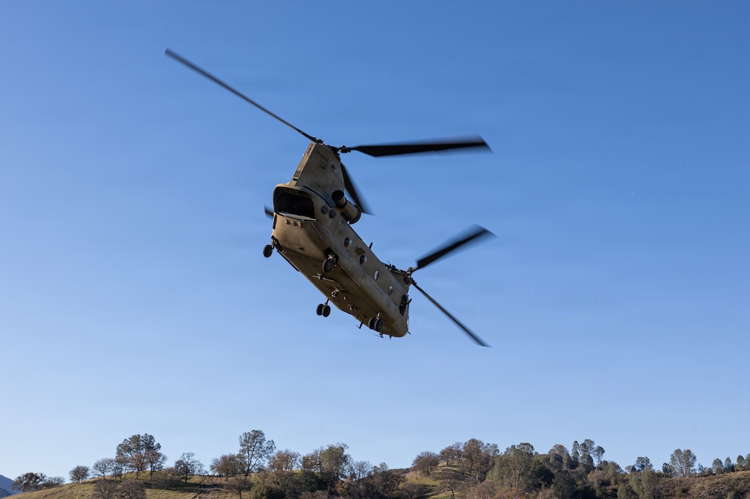 An Army CH-47F Chinook, with Bravo Company, 1st Battalion, 126th Aviation Regiment, from Stockton, Calif., flies over Fort Hunter-Liggett, Calif. during a Cold Weather Field Exercise on Jan. 9th, 2026. Marines assigned to Combat Logistics Battalion 23, 4th Marine Logistics Group conducted an aerial insert with support from U.S. Army Bravo Company, 1st Battalion, 126th Aviation Regiment, from Stockton, Calif. during a platoon-level defense training by delivering Marines and crew-served weapons directly into the training ground. (U.S Marine Corps photo by Sgt. Eduardo Delatorre)