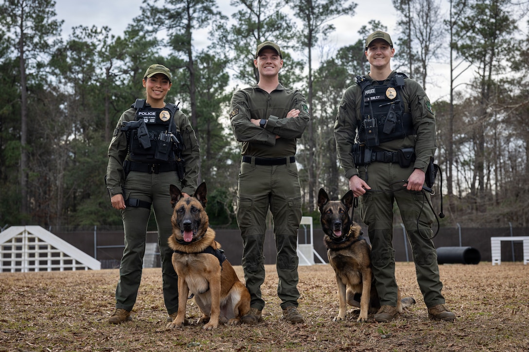 U.S. Marine Corps Lance Cpl. Alexandra Flores, left, a military working dog handler, Lord, a military working dog, Sgt. Andrew Sanderson, the military working dog trainer, Teo, a military working dog, and Officer Brenden Hernley, a military working dog handler, all assigned to Headquarters and Headquarters Squadron, Marine Corps Air Station Cherry Point, at MCAS Cherry Point, North Carolina, Jan. 14, 2026.
