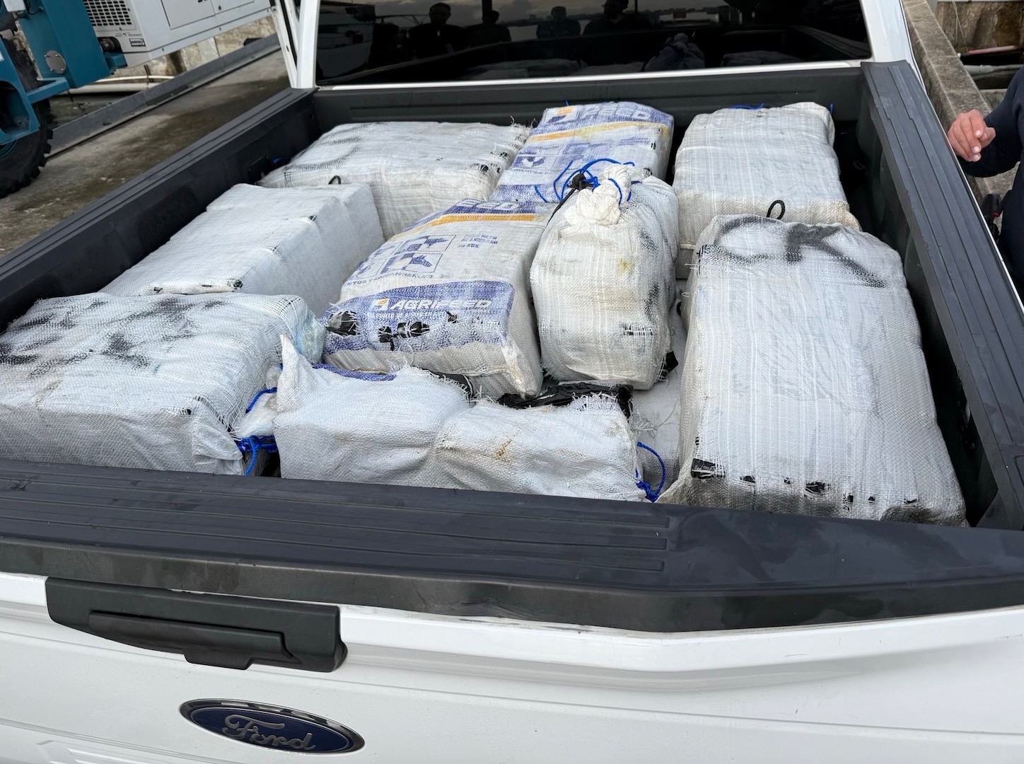 A Coast Guard Station San Juan boat crew and Homeland Security Task Force - San Juan Region partner agencies completed the custody transfer of three apprehended smugglers and the offload of sixteen bales of cocaine which weighed 506kgs/1,115.54 pounds which were valued at more than $7 million.  The apprehension and seizure followed the interdiction of a drug smuggling vessel in Atlantic Ocean waters north of Puerto Rico, Jan. 14, 2026. (U.S. Coast Guard photo)