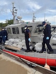 A Coast Guard Station San Juan boat crew and Homeland Security Task Force - San Juan Region partner agencies completed the custody transfer of three apprehended smugglers and the offload of sixteen bales of cocaine which weighed 506kgs/1,115.54 pounds which were valued at more than $7 million.  The apprehension and seizure followed the interdiction of a drug smuggling vessel in Atlantic Ocean waters north of Puerto Rico, Jan. 14, 2026. (U.S. Coast Guard photo)