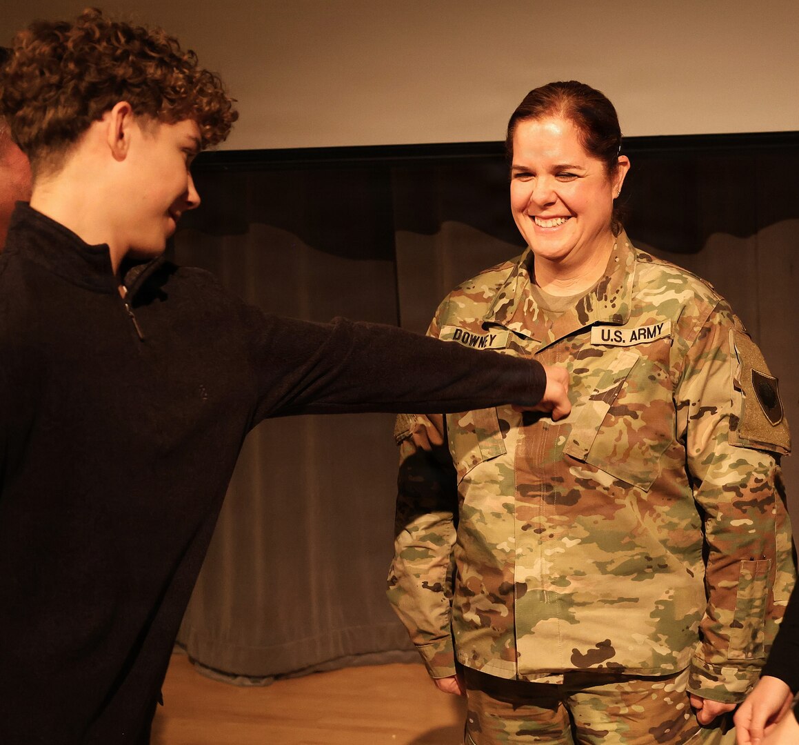 Illinois Army National Guard Chief Warrant Officer 4 Melissa Downey's 16-year-old son, Luke Hiller, 'punches' Warrant Officer 4 rank on his mother's chest during her promotion ceremony.