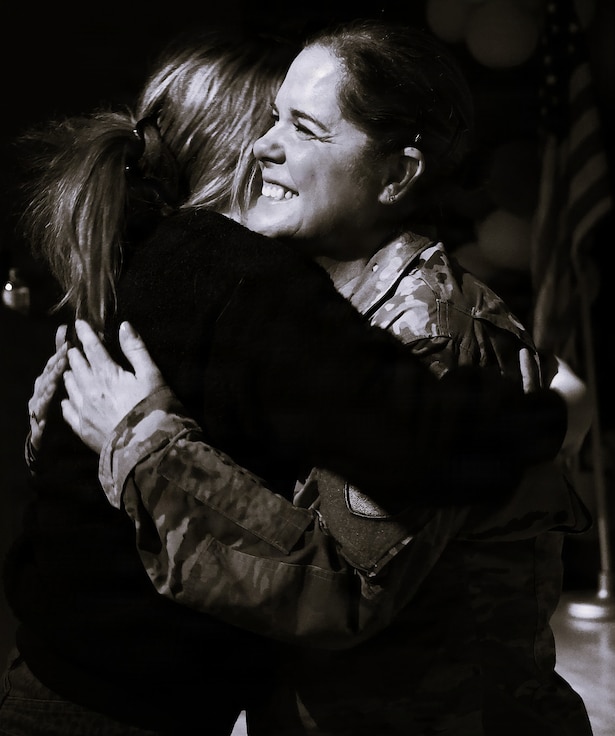 Illinois Army National Guard Chief Warrant Officer 4 Melissa Downey hugs her niece, Kaelan Loftus, after her promotion.