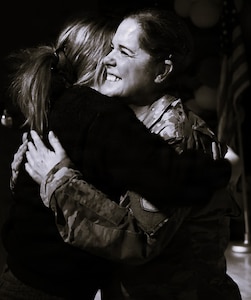 Illinois Army National Guard Chief Warrant Officer 4 Melissa Downey hugs her niece, Kaelan Loftus, after her promotion.