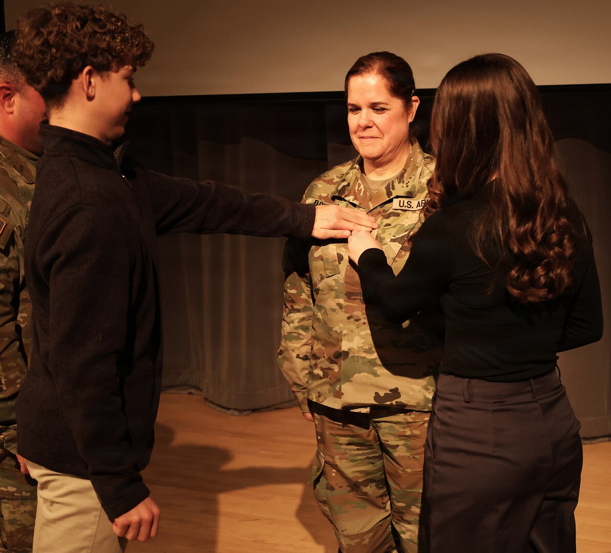 Illinois Army National Guard Chief Warrant Officer 4 Melissa Downey's 16-year-old son, Luke Hiller, 'punches' Warrant Officer 4 rank on his mother's chest during Downey's promotion ceremony.