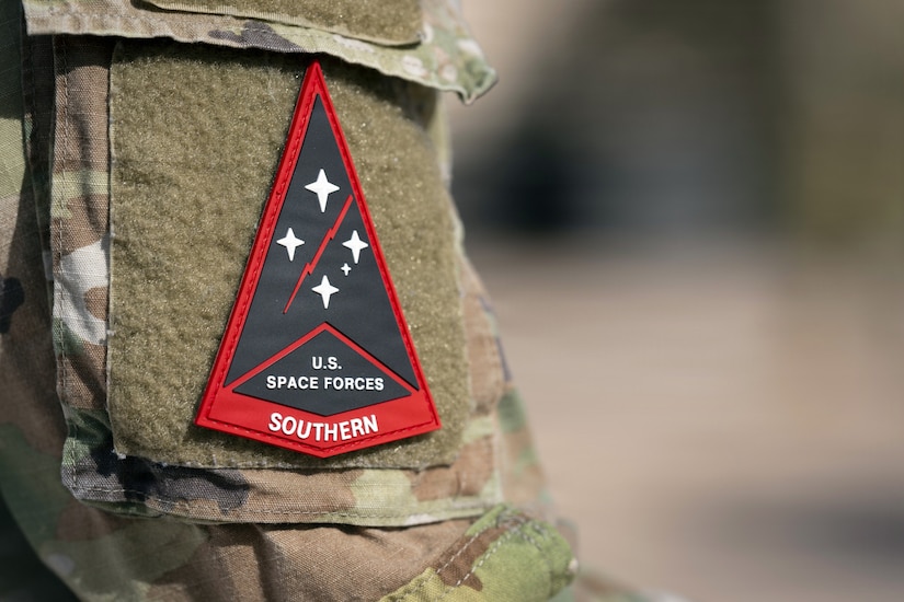 A red triangular patch with the words U.S. Space Forces Southern is shown on a camouflage military uniform.