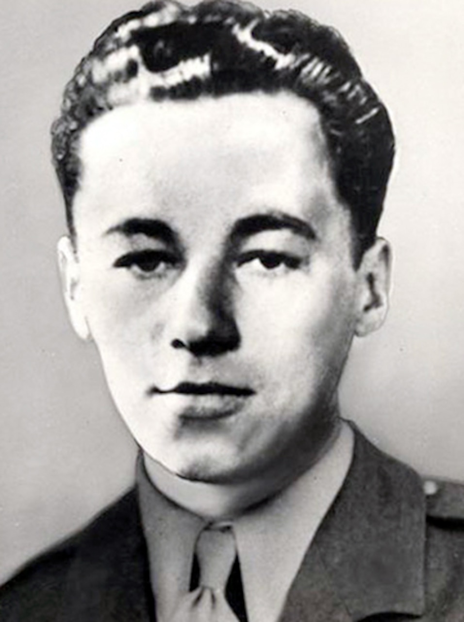 A man in a military dress uniform poses stoically for a photo.