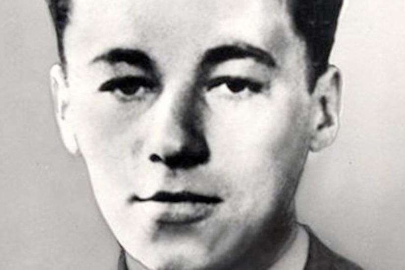 A man in a military dress uniform poses stoically for a photo.