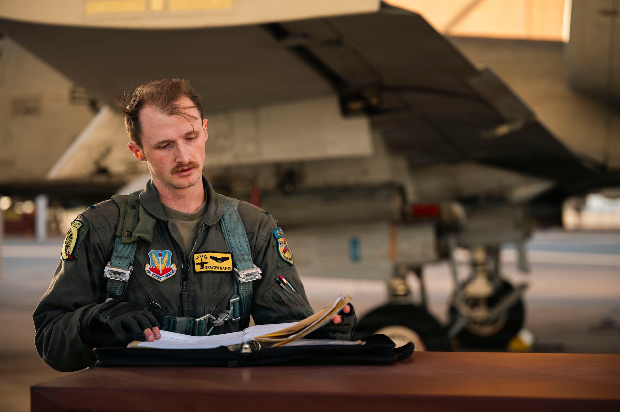 U.S. Air Force 1st Lt. Brayden Mathis, 357th Fighter Squadron A-10C Thunderbolt II aircraft student pilot, reviews aircraft forms before taking flight at Davis-Monthan Air Force Base, Arizona, Dec. 16, 2025. The aircraft forms are an essential part of the pre-flight process to validate aircraft readiness. (U.S. Air Force photo by Airman 1st Class Samantha Melecio)