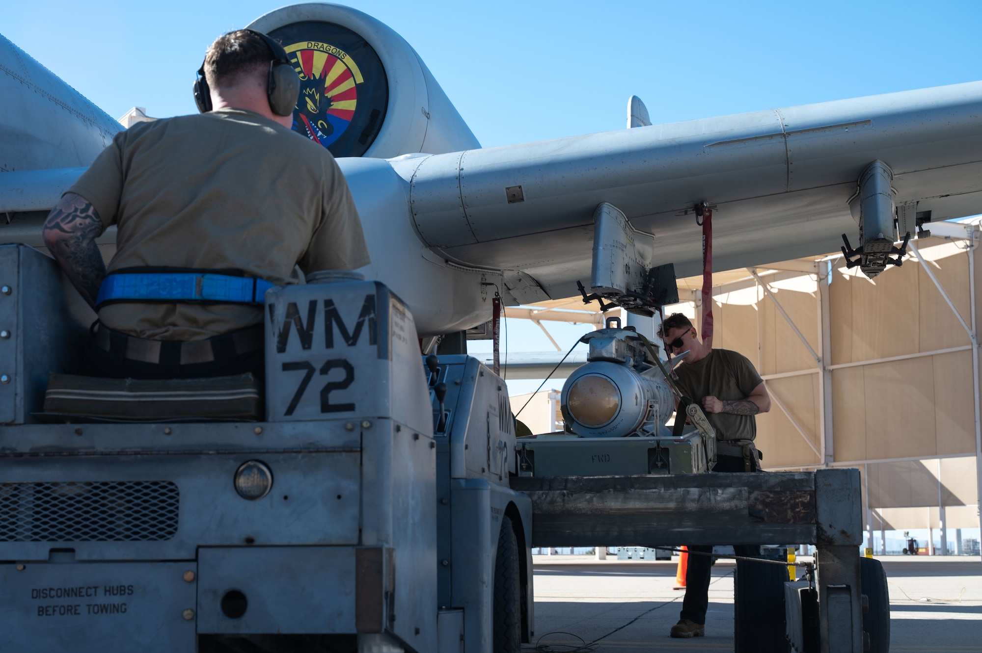 U.S. Air Force Senior Airman Gavin Gonzalez, left, and Staff Sgt. Collin Harvill, both 357th Fighter Generation Squadron weapons load crew members, compete in the 2025 Load Competition of the Year at Davis-Monthan Air Force Base, Arizona, Jan. 16, 2026. The competition highlighted the skill and professionalism of weapons load crews, proving the unit’s commitment to mission readiness. (U.S. Air Force photo by Airman 1st Class Jaden Kidd)