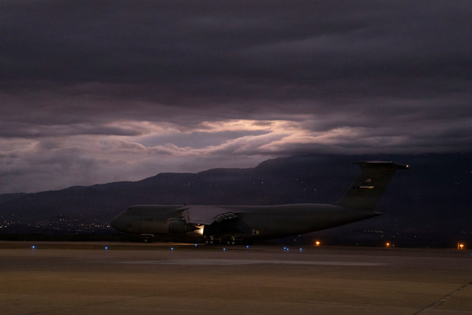 A military plane takes off from a runway.