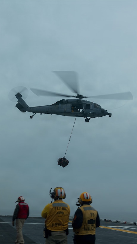 A U.S. Navy MH-60S Sea Hawk with Helicopter Sea Combat Squadron (HSC) 21, carries cargo off of the deck of Wasp-class amphibious assault ship USS Boxer (LHD 4), in the Pacific Ocean, Jan. 21, 2026.