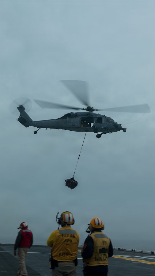 A U.S. Navy MH-60S Sea Hawk with Helicopter Sea Combat Squadron (HSC) 21, carries cargo off of the deck of Wasp-class amphibious assault ship USS Boxer (LHD 4), in the Pacific Ocean, Jan. 21, 2026. The 11th Marine Expeditionary Unit is currently underway aboard the Boxer Amphibious Ready Group in the U.S. 3rd Fleet area of operations conducting integrated training that enhances lethality and warfighting readiness. (U.S. Marine Corps photo by Lance Cpl. Nicole Stuart)