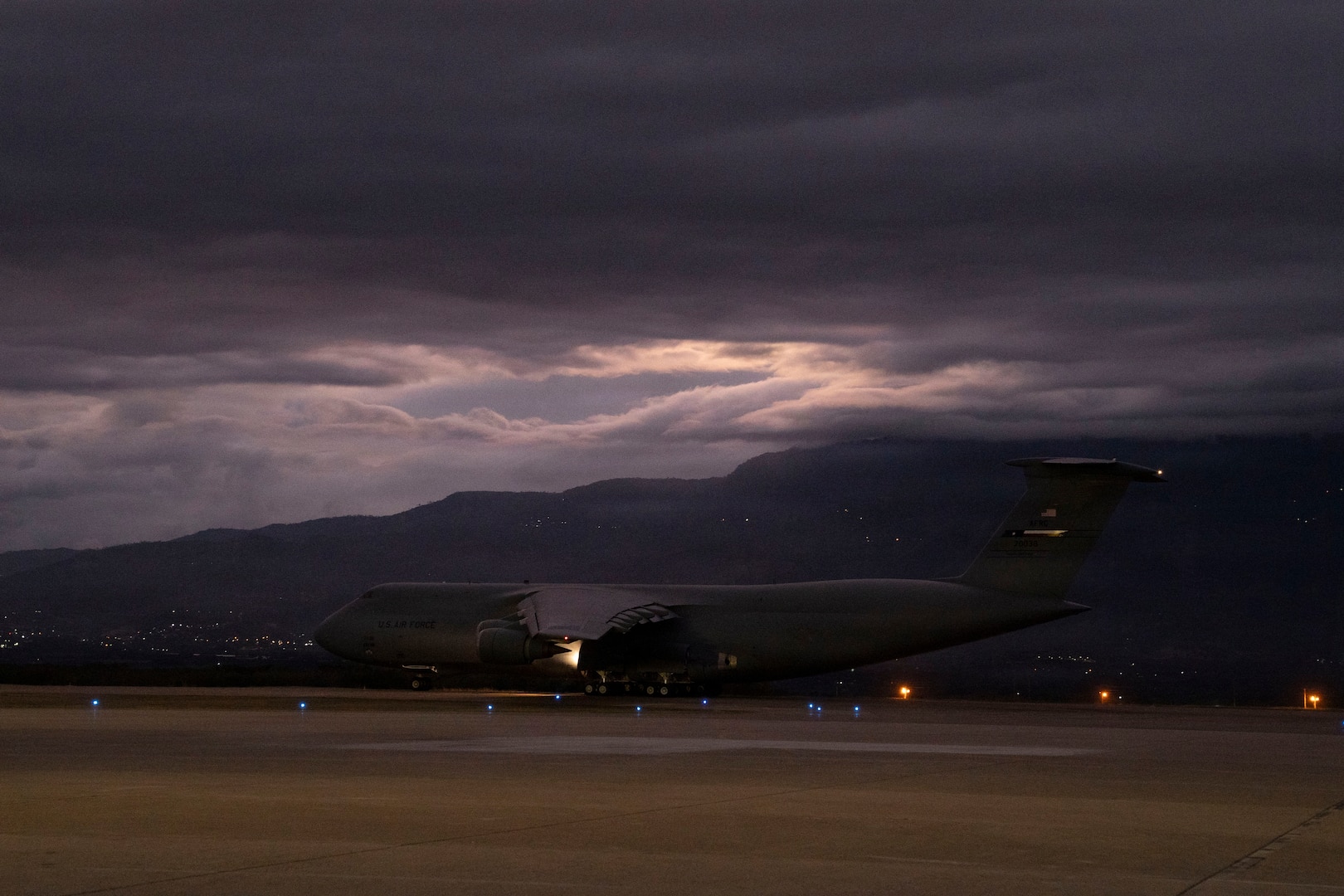 A military plane takes off from a runway.