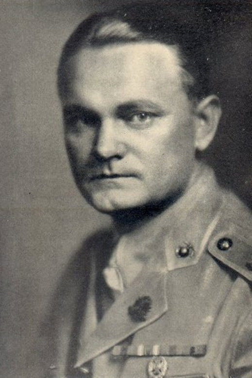 A man in a military dress uniform poses for a portrait.