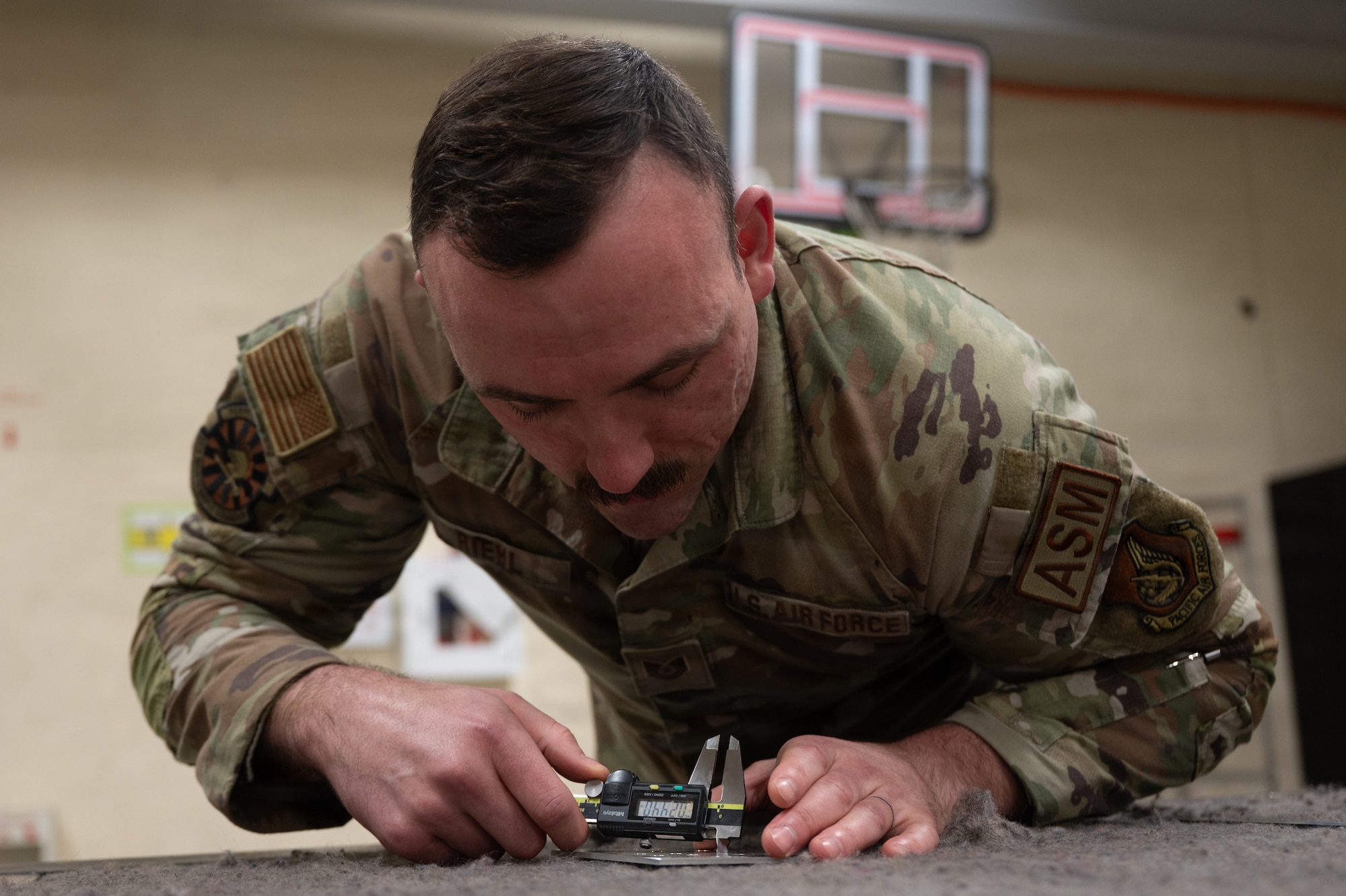 U.S. Air Force Tech. Sgt. Matthew Riehl, 35th Maintenance Group maintenance section chief, measures a steel rod at Misawa Air Base,
