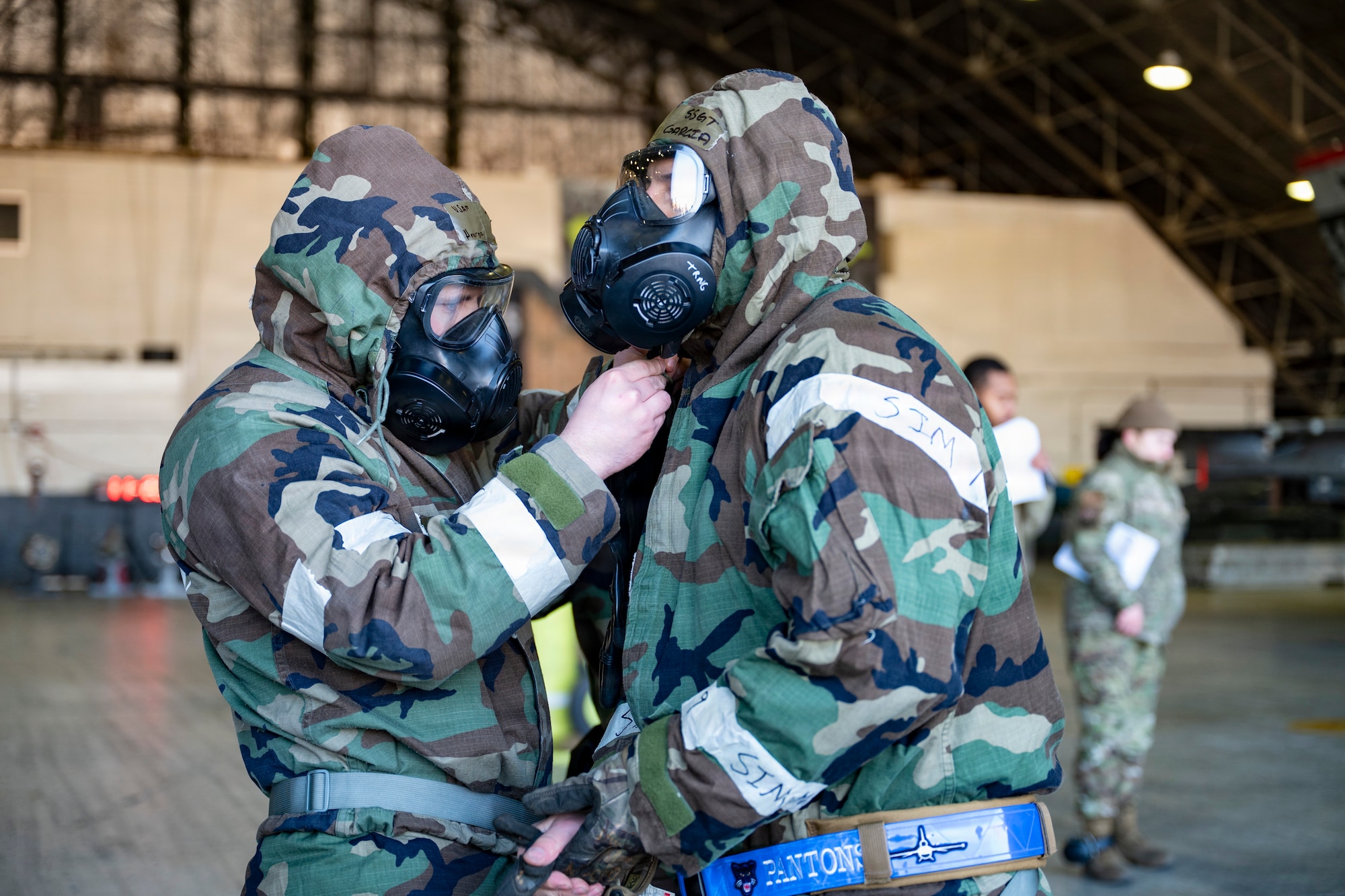 U.S. Air Force Airmen assigned to the 35th Fighter Generation Squadron assist each other in donning Mission Oriented Protective Posture gear during the Annual Bomb Build and Loading Competition at Osan Air Base, Republic of Korea, Jan. 22, 2026.