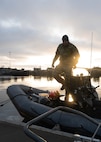 A U.S. Navy explosive ordnance disposal technician from EODMU 8 disembarks a rigid-hull inflatable boat during exercise Freezing Winds 25 in Upinniemi, Finland, Nov. 25, 2025.