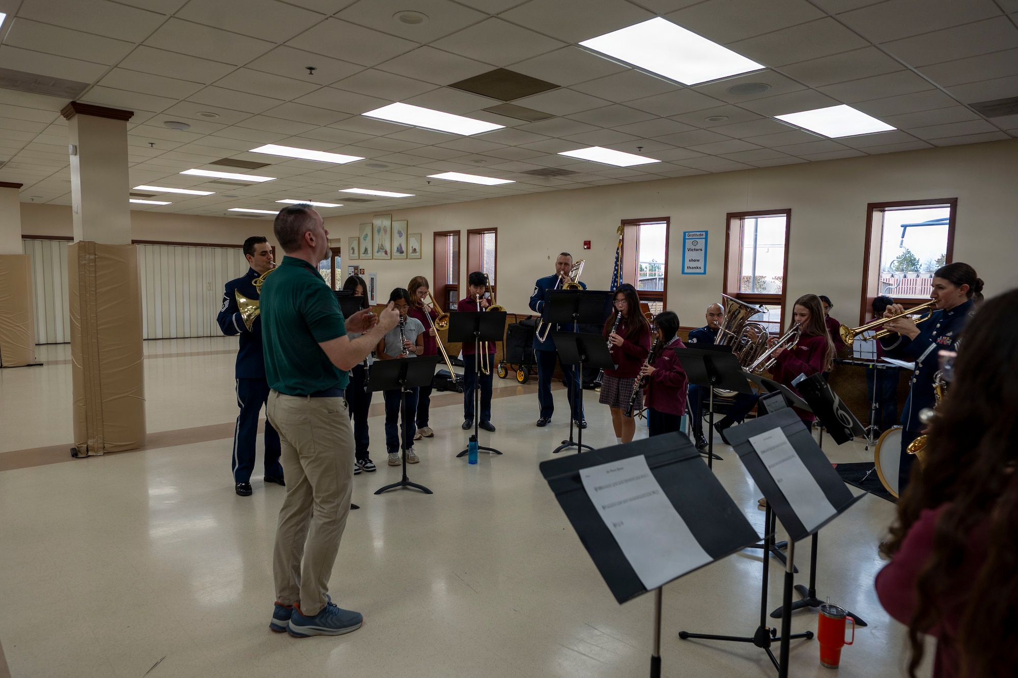 Chris Tolbert, St. Veronica’s Catholic School band director, conducts his students and The U.S. Air Force Band’s District Brass in Chantilly, Va., Jan. 13, 2026. Tolbert led the group in playing the Air Force Hymn to immerse students in playing alongside professional musicians. (U.S. Air Force photo by Staff Sgt. Jordan Powell)